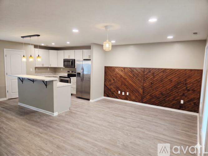 A kitchen with a white counter and a wooden backsplash.