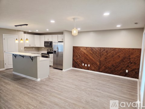 A kitchen with a white counter and a wooden backsplash.