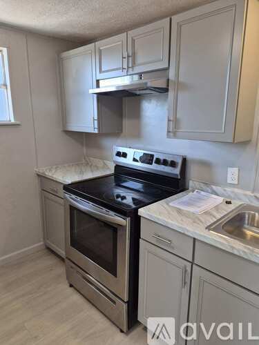 A kitchen with a stove top oven and a sink.