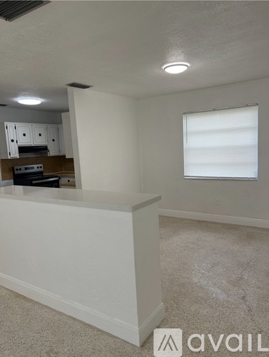 A kitchen area with white cabinets and a counter.