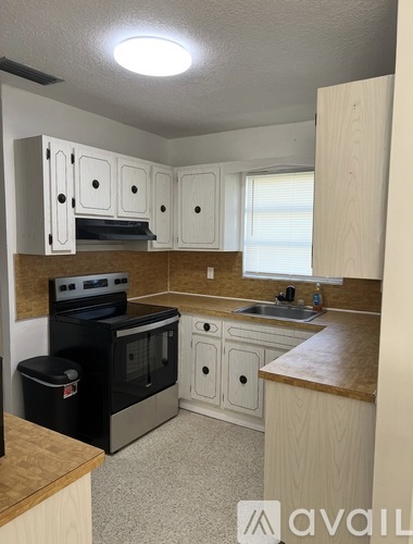 A kitchen with white cabinets and a black oven.