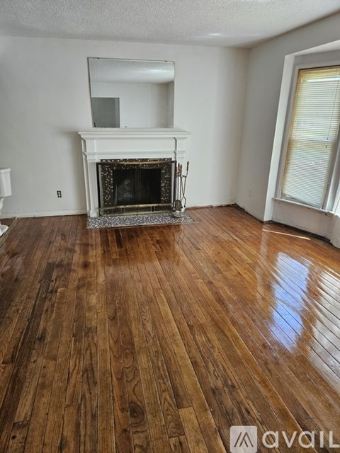 A room with a fireplace and wooden floors.