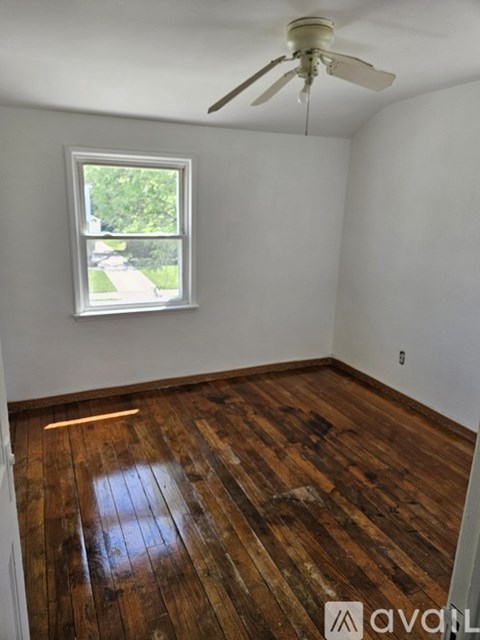 A room with a window and a ceiling fan.