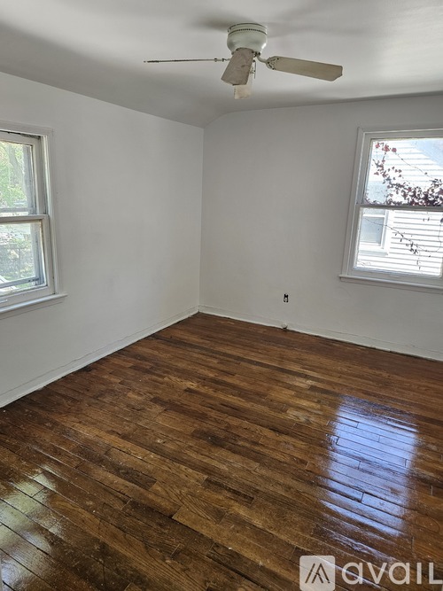 A room with wooden floors and a ceiling fan.