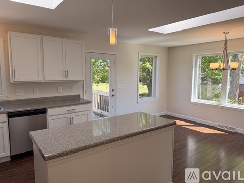 A kitchen with white cabinets and a granite countertop.