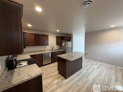 A kitchen with wooden cabinets and a granite countertop.