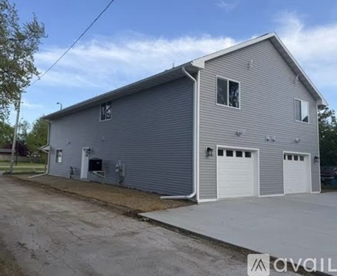 A grey building with a sign that says "AVAIL" in front of it.