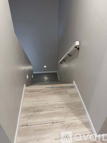 A wooden staircase with a metal handrail.