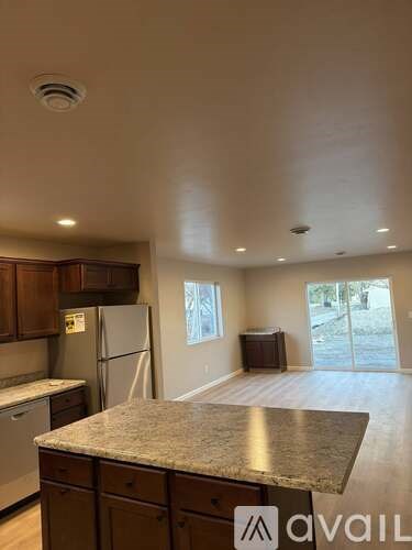 A kitchen with granite countertops and wooden cabinets.