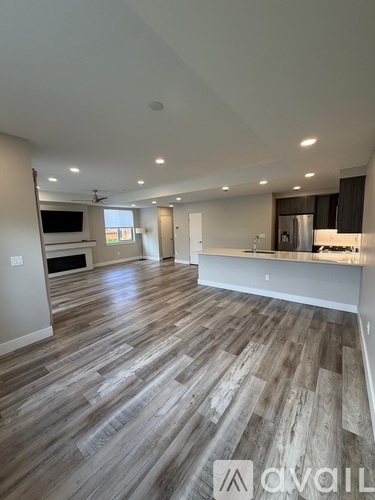 A spacious room with wooden flooring and a television in the corner.