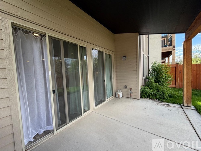 A patio area with a sliding glass door and a white curtain.