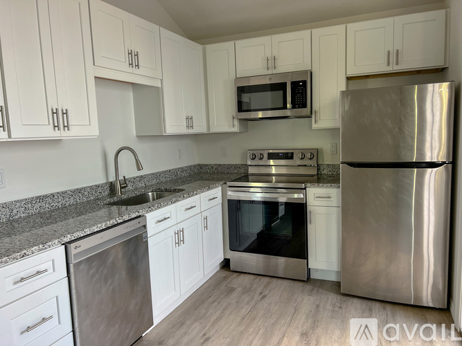 A kitchen with white cabinets and stainless steel appliances.