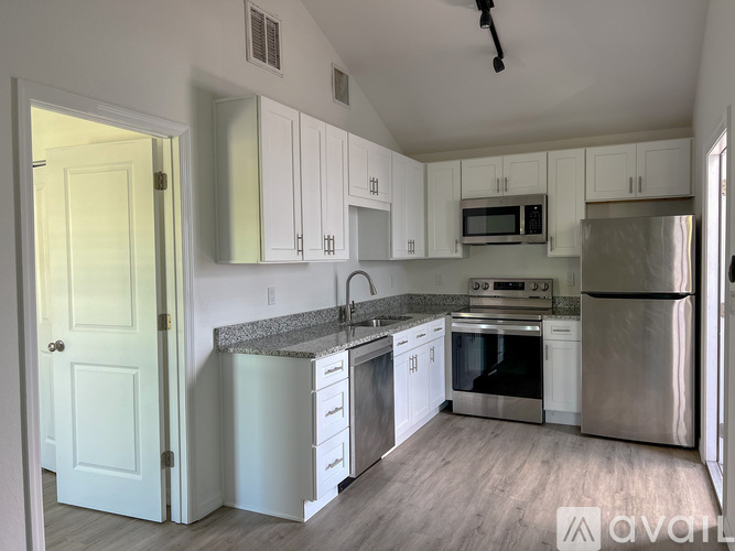 A kitchen with white cabinets and stainless steel appliances.