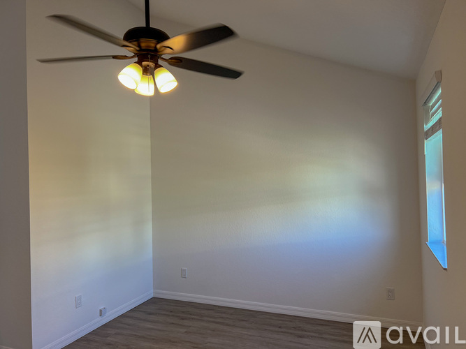 A room with a ceiling fan and a window.