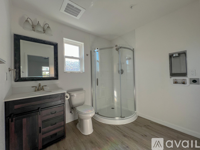 A bathroom with a toilet, sink, and shower.