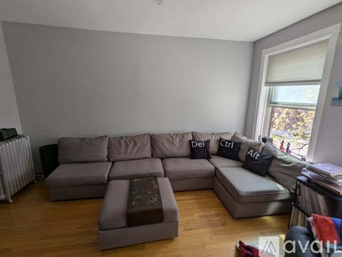 A grey sectional sofa with pillows and a coffee table in a living room.