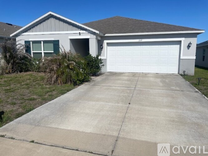 A house with a garage and a driveway in front.