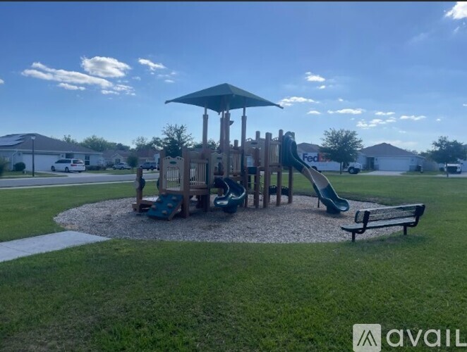 A playground with a green slide and a wooden structure.