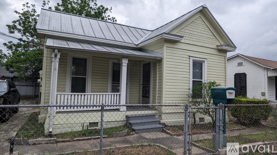 A house with a metal roof and a porch with a railing.