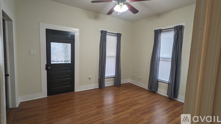 A room with a ceiling fan and a door with a window.