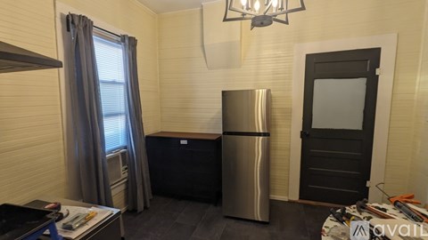 A kitchen area with a stainless steel refrigerator and a black dishwasher.