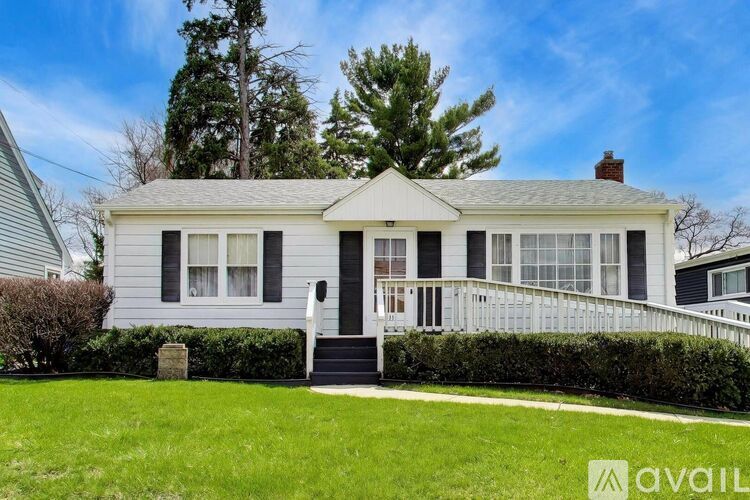 A house with a front porch and a well-maintained lawn.