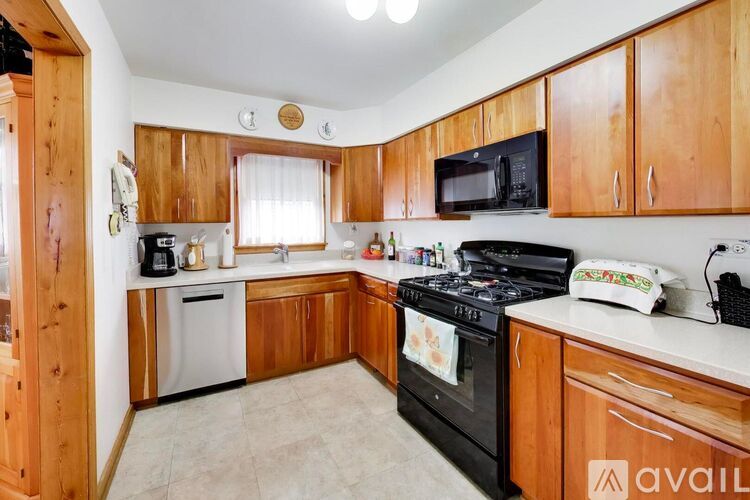 A kitchen with wooden cabinets and a black stove top oven.