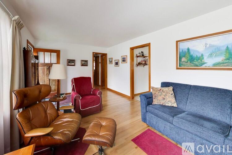 A living room with a blue couch and brown leather chairs.