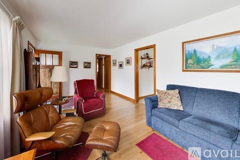 A living room with a blue couch and brown leather chairs.