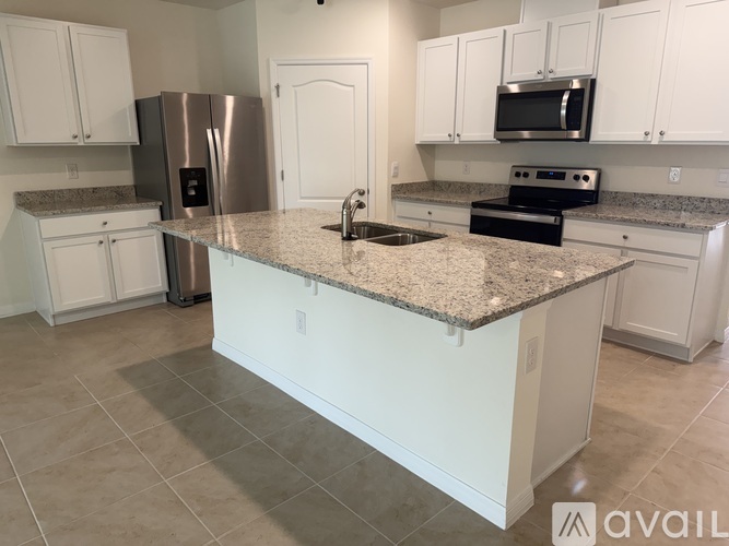 A kitchen with granite countertops and white cabinets.