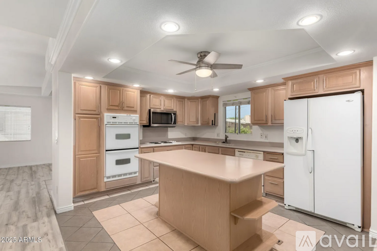 A kitchen with wooden cabinets and a white refrigerator.