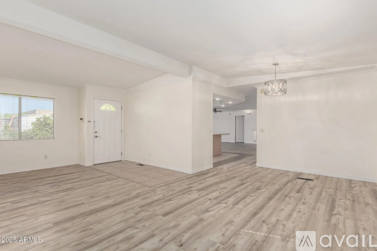 A spacious room with wooden flooring and white walls.
