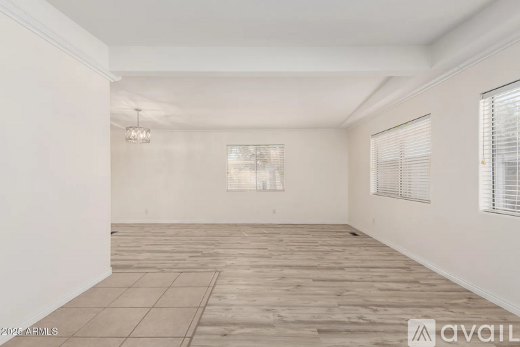 A spacious room with wooden flooring and white walls.