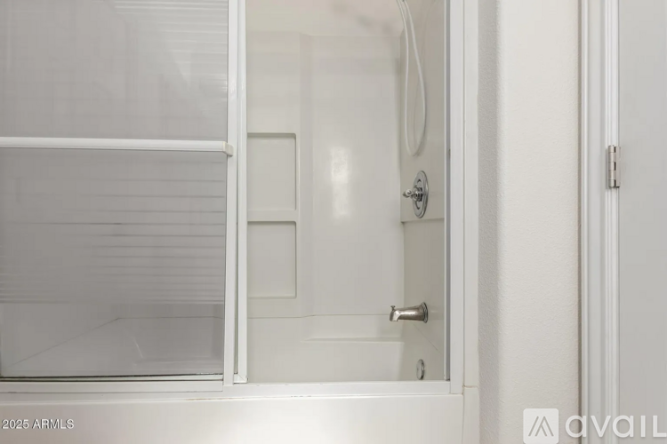 A white bathroom with a glass shower door.