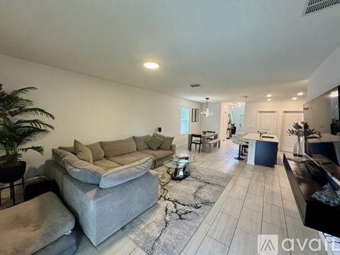 A living room with a grey sofa and a black coffee table.