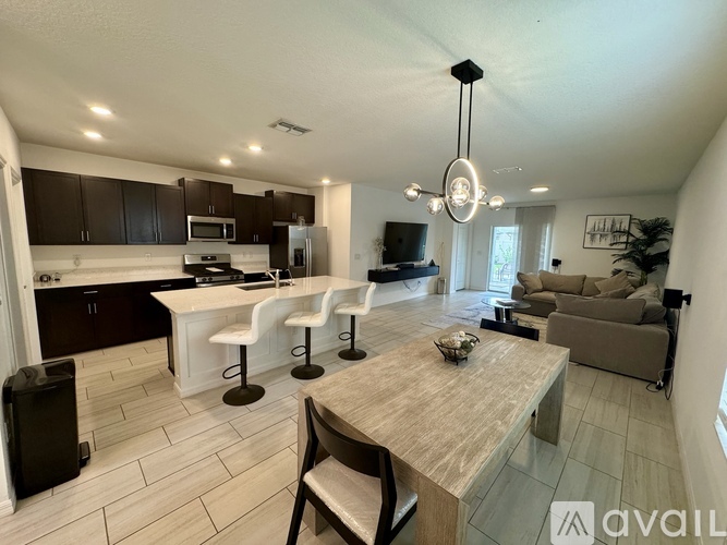 A modern kitchen with dark brown cabinets and white countertops.
