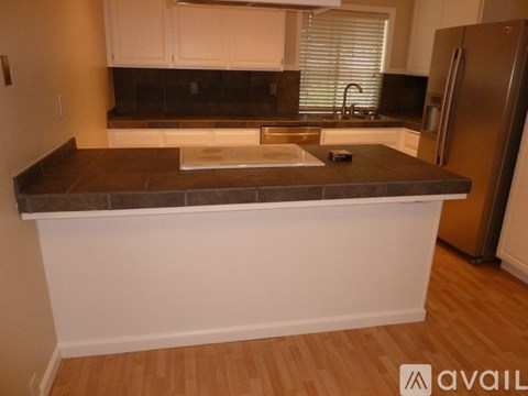 A kitchen with a white counter and a refrigerator.