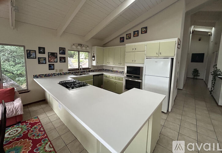 A kitchen with a white countertop and a white refrigerator.