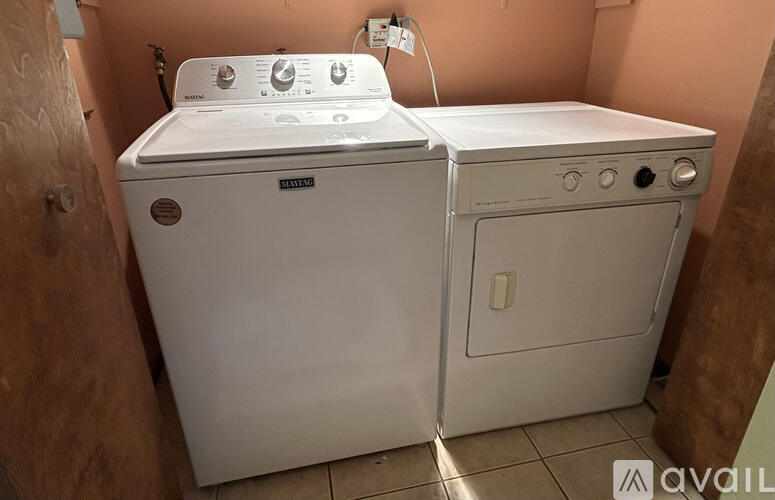 A white washing machine and dryer are sitting next to each other.