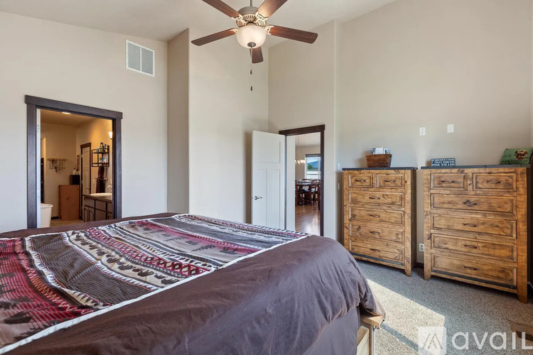 A bedroom with a large bed and a ceiling fan.