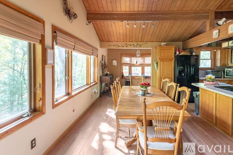 A wooden dining table with chairs is in a room with wooden walls and ceiling.