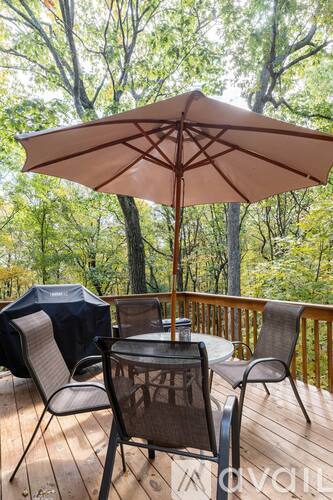 A patio with a table, chairs and an umbrella.