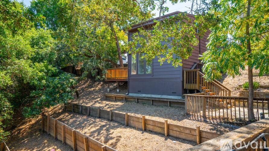 A house with a deck surrounded by trees.