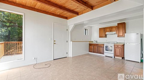 A kitchen with wooden cabinets and a white refrigerator is available for rent.