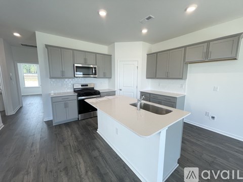 A kitchen with a white island and wooden floors.