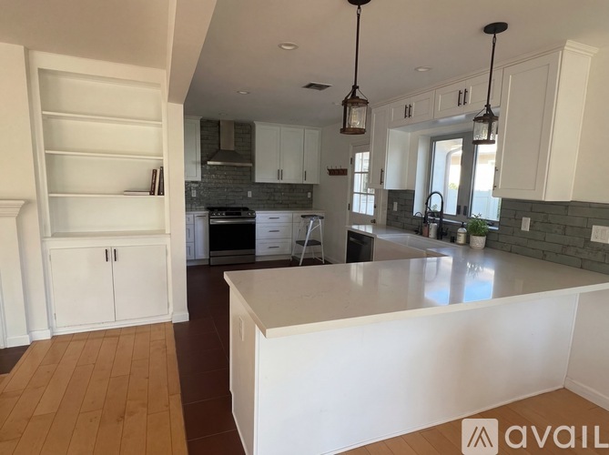 A kitchen with white cabinets and a large island.