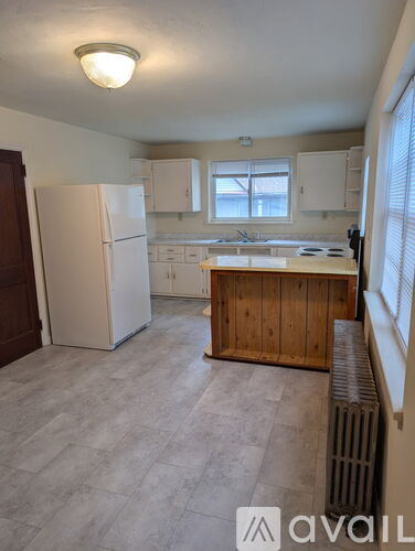 A kitchen with a white fridge and wooden cabinets.