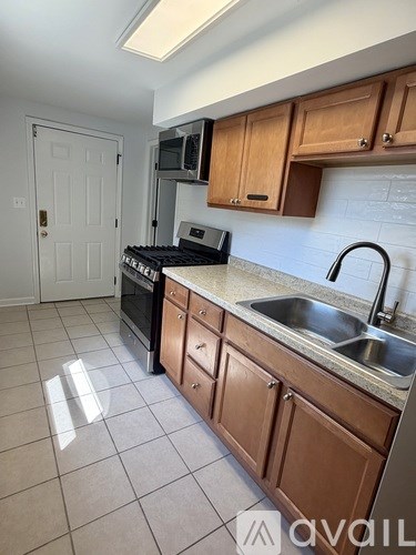 A kitchen with wooden cabinets and a white door.