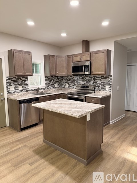 A kitchen with wooden cabinets and a stone backsplash.