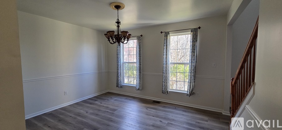 A room with a wooden floor and a chandelier hanging from the ceiling.